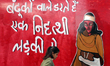 A student passes by a graffiti painted in a protest against the Citizenship Amendment Act...