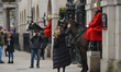 Tourists takes pictures with a mounted trooper of the Household Cavalry on duty at Horse G...