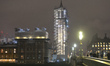 A night view of a part of Westminster Palace and Big Ben covered in scaffolding during ren...