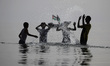 Palestinians swim in the Mediterranean Sea off the coast of Gaza City as they enjoy a warm...