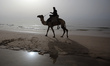A Palestinian man rides his camel on a beach of Gaza City. April, 20, 2015. 