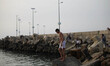 Palestinian families swim and palestinian youth jumps into the Mediterranean Sea as he enj...