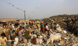 Indians look for recyclable material at a dumping site on the eve of World Earth Day in Gu...