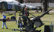 Children play with antiaircraft gun as a part of exhibition,during a graduation ceremony a...