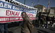 A pensioner in front a banner that reads - Social security is not a merchandise is a right...