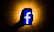 In this photo illustration the Facebook logo is seen displayed on smartphone screen in thi...