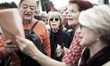 People sing in front of the ancient Pyramid of Cestius during a rally to mark the annivers...