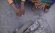 A Hindu Sadhu or Holy Man warm themselve in fire during Maha Shivaratri at the premises of...