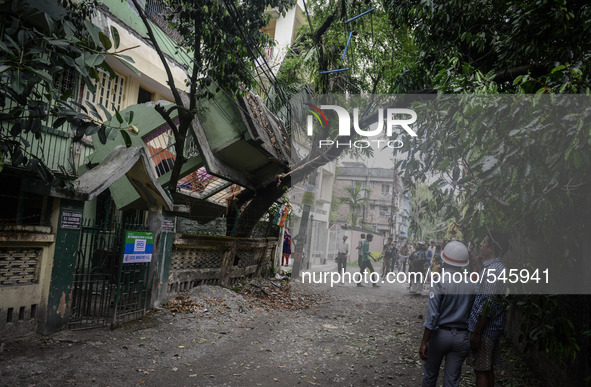 Indian bystanders look at a collapsed house following an earthquake, in Siliguri on April 25, 2015. A powerful 7.9 magnitude earthquake stru...