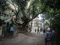Indian bystanders look at a collapsed house following an earthquake, in Siliguri on April 25, 2015. A powerful 7.9 magnitude earthquake stru...
