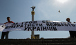 Two men holds a placard which says "Separatists kill Ukrainians for Mr. Yefremov's money"...