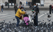 People and tourists wearing a protective mask walks on Piazza Duomo in Milan, Italy, on Fe...