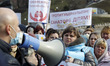 Ukrainian medical workers wearing face masks participate at a rally against health reform,...