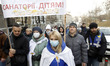 Ukrainian medical workers wearing face masks participate at a rally against health reform,...