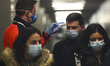 Health personnel monitors body temperature of passengers who arrived in a flight from Mila...