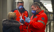 Health personnel monitors body temperature of passengers who arrived in a flight from Mila...