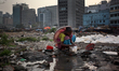 Monowara Begum (70), washes her kitchen staff as a water pipe leaked beside her slum near...