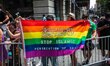 Muslim parade goer holds up a pride flag with the message to "Stop Islamic Persecution of...