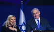Israeli Prime Minister Benjamin Netanyahu stands next to his wife Sara as he speaks to sup...