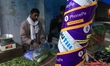 PhonePe stickers are pasted on a pillar as a vendor is selling vegetables in New Delhi,  I...