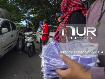 An administrator of the Indonesian-Chinese Association (INTI) distributed free masks to motorists on one of the roads in Palu, Central Sulaw...