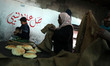 Palestinian women receive bread in a bakery in Rafah in the southern Gaza Strip,on March 1...