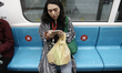 People sit at a distance marked by red cross sign on the MRT Jakarta train in Jakarta, Ind...