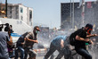 ISTANBUL, TURKEY--Journalists run as police fire water cannons in their direction during c...