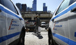 Passerby look on near two police cars, in New York, United States, on March 24, 2020.  	In...
