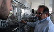 Nadeem inspects wine bottling machines in his winery in Taybeh village, Ramallah city of t...