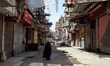 Cairo, Egypt, April 3, 2020 A woman walks in front of closed shops in Cairo, as the Egypti...