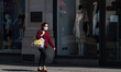 A woman wearing a face mask walks down Regent Street in central London as the UK's nationw...