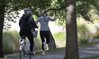 A woman takes selfies as she jogs at Hagley Park North in Christchurch, New Zealand, on Ap...
