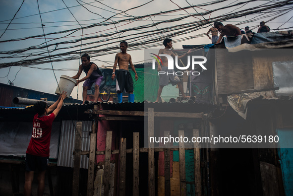 Some men work to extinguish the fire that broke out in a slum area in Tondo, Manila in the Philippines on April 18, 2020. About 500 families...