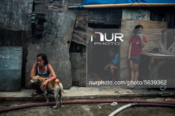 Residents watch as firefighters try to put out the fire that broke out in a slum area in Tondo, Manila in the Philippines on April 18, 2020....