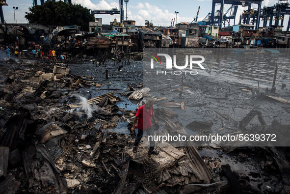 A man walks on the debris of his house destroyed after a fire broke out in a slum area in Tondo, Manila in the Philippines on April 18, 2020...