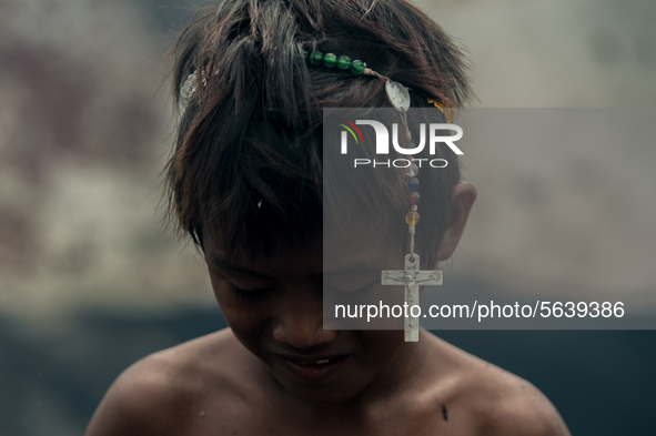 A boy wears a rosary on his head after a fire broke out in a slum area in Tondo, Manila in the Philippines on April 18, 2020. About 500 fami...