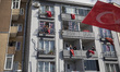 People celebrate with Turkish flags on their balconies to mark the National Sovereignty an...
