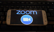 ZOOM Video Communications logo displayed on a phone screen, thumbnails of the application,...