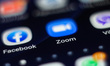 ZOOM Video Communications logo displayed on a phone screen, thumbnails of the application,...