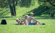 Three men with identical bleach blonde hair sunbathe in the sunshine in Peel Park, Salford...