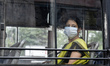 A woman board a bus after state authorities eased restrictions on inter-district travel fo...