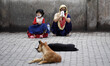 A woman with her daughter waiting for a bus after state authorities eased restrictions on...