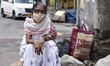 An elderly woman waiting for a bus after state authorities eased restrictions on inter-dis...