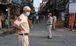 Delhi police stand outside a busy lane to enforce lockdown near Grand Mosque of Delhi Jama...