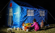 A girl is making dinner in front of her new tent donated by China. Tudikhel temporary shel...