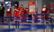 A cabin crew of Air Asia wearing a face mask and gloves at check-in counter of erminal 2 D...