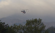 A firefighting helicopter carries out an operation to extinguish a forest fire in Goseong,...
