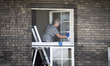 A woman cleans windows in a monastery in Warsaw, Poland on April 20, 2020. 