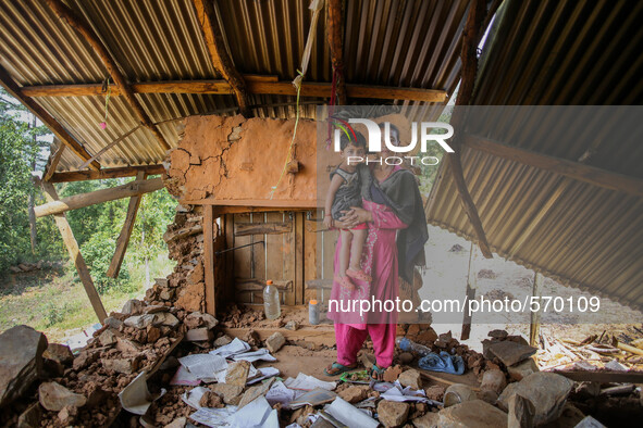 Kamala is standing with her daughter Nirjala in her destroyed house. Bandevi village, Kabrepalan Chowk, Nepal. May 6, 2015 